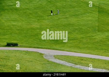 Munich, Germany - April 18, 2024: Green field in Olympiapark which is an Olympic Park which was constructed for the 1972 Summer Olympics Stock Photo