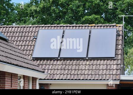 flat solar heat panels installed on the roof of a residential home, showcasing the integration of renewable energy in modern living. A demonstration o Stock Photo