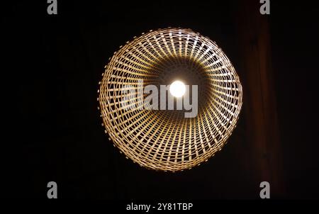 Uprisen view of basketry weave bamboo woven design lamp thai style handmade craft hanging from ceiling, local material decoration Stock Photo