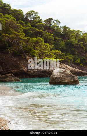 A large rock is prominently positioned in the middle of a body of water, Stock Photo