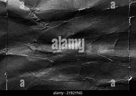 Black paper background with wrinkles, folds and crumpled distressed surface. Abstract grunge poster Stock Photo