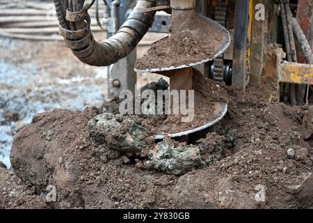 Auger pile drilling machine drilling hole in clay soil Stock Photo