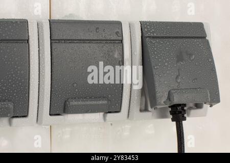 Outdoor electrical socket covered with water droplets Stock Photo
