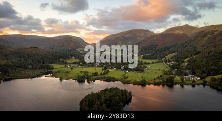 Aerial panoramic landscape of the Lake District village of Grasmere above Grasmere lake with surrounding mountains at sunset Stock Photo