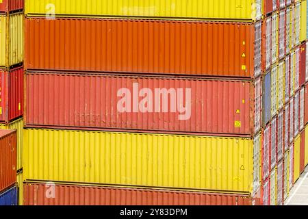 Yellow, orange and red cargo containers stacked in several layers at the port terminal Stock Photo