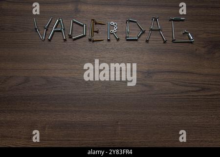 Dutch text Vaderdag made of screws on a dark wooden background, Father's Day concept Stock Photo