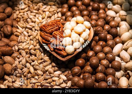 Mixed nuts background. Pecans, pistachios, macadamia nuts in shell and peeled top view. Stock Photo