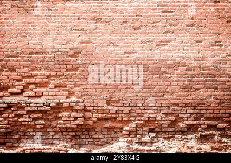 A brick wall is a sturdy structure made of bricks and mortar. It provides privacy, security, and aesthetic appeal to buildings. durability and timeles Stock Photo