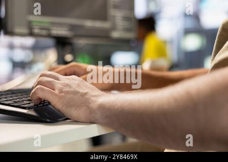 Programmer types on keyboard, testing company software to minimize occurrence of bugs, identifying bottlenecks. Close up of man writing clean, efficient code in programming language to reduce glitches Stock Photo
