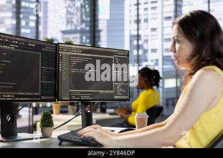 Computer technician working, designing and developing software applications. IT specialist in modern workspace typing on PC keyboard, implementing and maintaining company systems Stock Photo