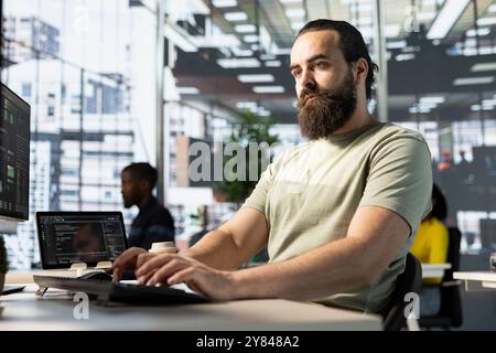 Programmer conducting experiments and tests to optimize machine learning models for performance and accuracy. IT employee in office analyzing and interpreting complex data Stock Photo