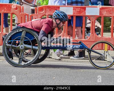 A man in a racing wheelchair competing in a half marathon. Stock Photo