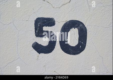 Dark blue number 50 painted on a bright, cracked white wall, Sandnes, Fylke Rogaland, Norway, Europe Stock Photo