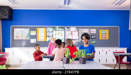 In school, diverse children working together on plant project in classroom Stock Photo