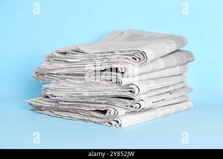 Stack of newspapers on light blue background Stock Photo
