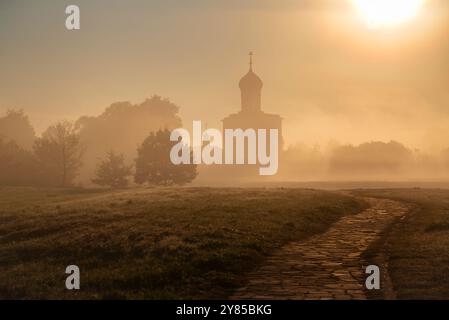 The path to the ancient Church of the Intercession on the Nerl in the fog at dawn. Bogolyubovo, Golden ring of Russia Stock Photo