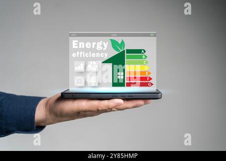 Energy efficiency concept. Person using tablet with energy efficiency rating icon on virtual screen for energy efficient house building rate label aud Stock Photo