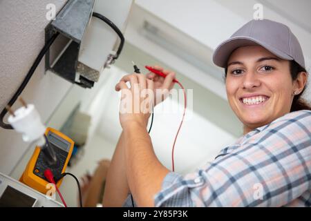 female electrician using multimeter to test an appliance Stock Photo