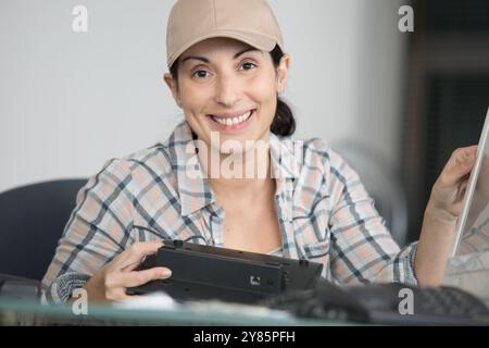 brunette smiling and fixing mechanism of printer Stock Photo