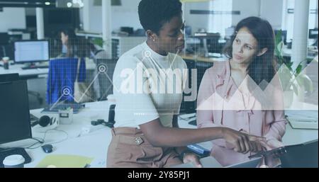 Business data analytics image over two women collaborating in modern office Stock Photo