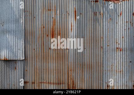 Front view of a rusty and weathered corrugated iron metal construction site wall. High resolution full frame textured grunge rust background. Stock Photo