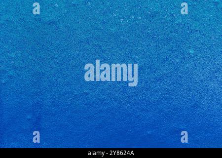 Close-up of a light blue wall spray painted with blue. Abstract full frame textured grunge graffiti background with copy space. Stock Photo