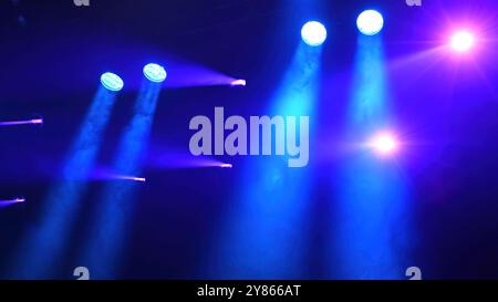 blue spotlights over the stage working during the concert Stock Photo