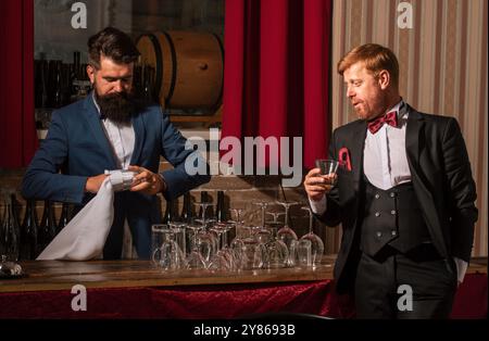 Bartender and customer. Barman at counter. Hipster in bar. Old traditional whiskey drink. Gentlemans beverage. Stock Photo