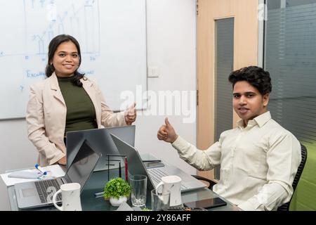 2 Business person smiling multiracial colleagues posing in office show thumbs up recommend good service, happy diverse businesspeople give recommend Stock Photo