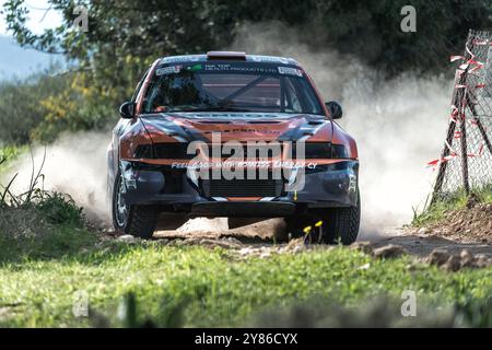 Anogyra, Cyprus - January 29, 2023: Mitsubishi rally car racing on dirt track raising dust at high speed Stock Photo