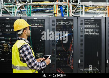 Young technician man working inside big data center room - Technology, cyber security and AI concept - Focus on person nose Stock Photo