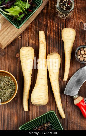 Uncooked parsnips roots on the kitchen table. Fresh vegetable. Top view. Stock Photo