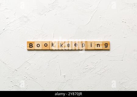 bookkeeping word written on wood block. bookkeeping text on table, concept. Stock Photo