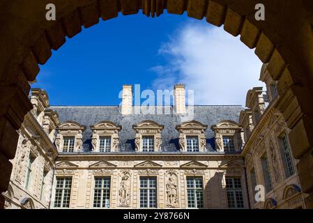 Paris, France, View through the arch on beautiful architectural details of the facade of the 'hôtel de Sully' in the Marais. Historical monument Stock Photo