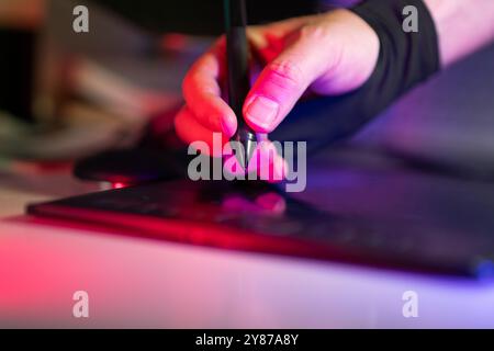 Graphic designer digital tablet stylus home studio interior neon light Stock Photo