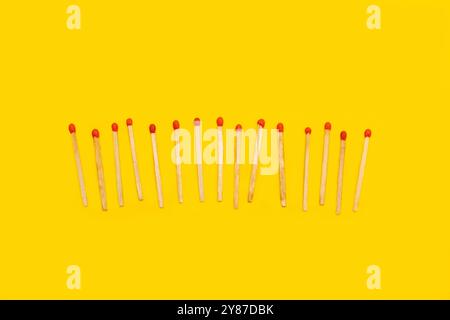 Wooden matches sticks on a yellow background with copy space Stock Photo