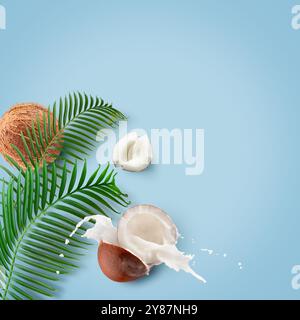 coconuts with milk splash and leaf on a light blue background. Stock Photo