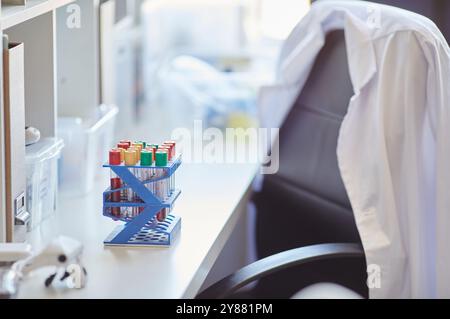 Empty doctors working table with multiple test tubes filled with blood or chemicals in hospital laboratory, copy space Stock Photo