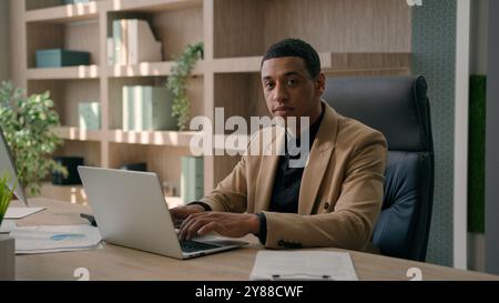 Portrait of serious African American man entrepreneur commercial business work at office male businessman CEO chief working with laptop computer Stock Photo