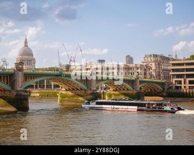 Uber Boat by Thames Clippers river boat service passing under Southwark Bridge on the Thames, London, UK Stock Photo