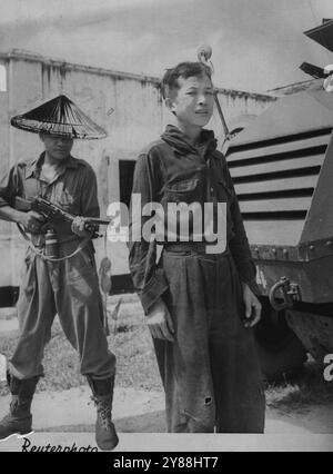 Lyttelton's Malaya Visit: A Chinese Communist Arrested -- Intensified Police action to protect Mr. Oliver Lyttelton, 58-year-old British Colonial Secretary during his visit to Malaya, turns up this 35-year-old Chinese Communist guerilla. Pictured here as he is brought in guarded the man -- his name is Ngue Sam -- was captured in Bentong Pahang the day Mr. Lyttelton was visiting the town. The guerilla was ***** with a hand grenade. December 8, 1951. (Photo by Reuter Photo). Stock Photo