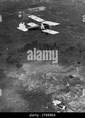 About to Make a Thrilling Parachute Jump:-- This unique photograph. taken from another airplane. shows Pilot Officer 'Scotty' Fraser just before jumping from an airplane to make a delayed descent from height of 2000 feet. He his four complete somersaults before before releasing the parachute. His daring displays have thrilled large crowds in all parts of New Zealand. This picture was secured during a recent aerial display at Auckland. May 17, 1932. Stock Photo