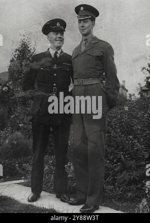 High, Soldier -- Six-foot eight-inch tall Lance-Corporal Peter Martin, of Bilton Road, perivale, Middlesex, is the tallest member of the Queen's Company, Grenadier Guards. Admittedly he doesn't tower over his father, police Inspector Albert Martin, but then, father is no dwarf. In fact he is 6ft. 5ins. tall. August 26, 1953. Stock Photo