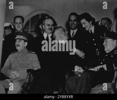 Allied Leaders And Members of Their Staffs At Historic Teheran Conference -- Seated between Marshal Joseph Stalin (left), Russian Premier, and British Prime Minister Winston Churchill, President Franklin D. Roosevelt of the U.S. shakes hands with Section Officer Sarah Oliver of the British Women's Auxiliary Air Force, daughter of Mr. Churchill, outside the Russian Embassy at Teheran, Iran, where historic conferences were held completing plans for the destruction of the Germen Military forces. Behind the Allied leaders are left to right; Harry L. Hopkins, Special Assistent to President Roosevel Stock Photo