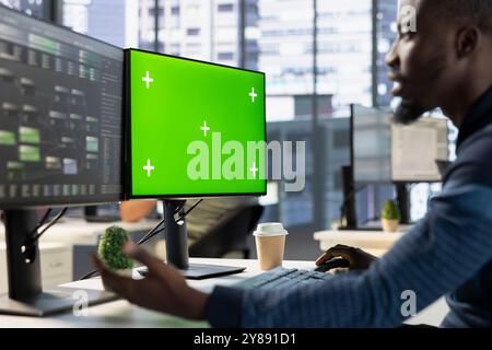 Admin using chroma key PC to develop machine learning APIs solving complex problems. IT specialist training predictive models capable of handling complex tasks using green screen computer Stock Photo