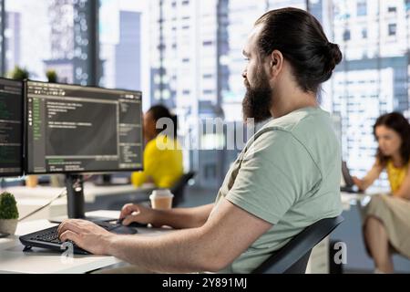 Computer scientist testing and debugging company software to minimize occurrence of bugs, identifying bottlenecks. IT expert in office writing clean code in programming language to reduce errors Stock Photo