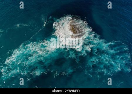 waves break on an exposed rock in the ocean Stock Photo