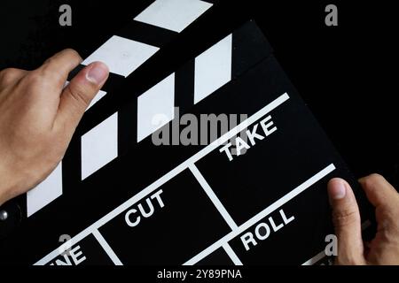hand hold clapperboard on black background Stock Photo