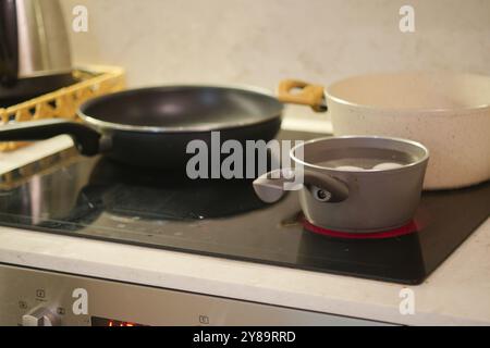 A Beautiful Cookware Collection Displayed on an Induction Stove in a Modern Kitchen Space Stock Photo