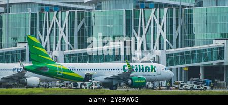 Balikpapan, Indonesia - September 26th, 2024. A Citilink passenger jet parked at Balikpapan airport terminal. The plane is surrounded by ground crew a Stock Photo